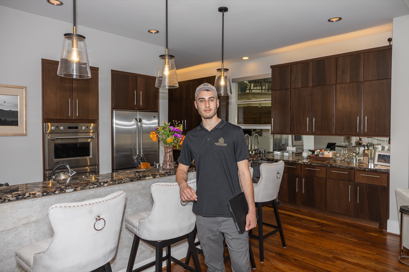 Yuval Carmel in a remodeled kitchen wearing his remodeling company shirt